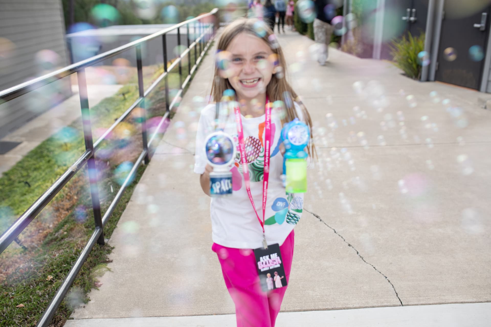 Young girl smiling while blowing bubbles at BLUSH